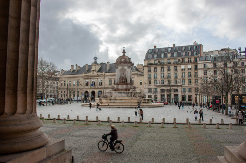 A cyclist rides through a european city square