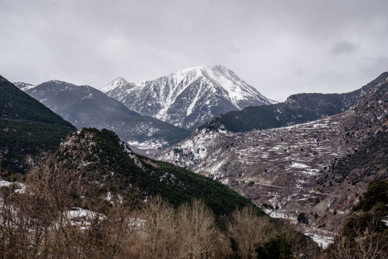 Vue pittoresque des Pyrénées enneigées sous un ciel nuageux à Espot, en Espagne, mettant en avant la beauté naturelle et le terrain accidenté.