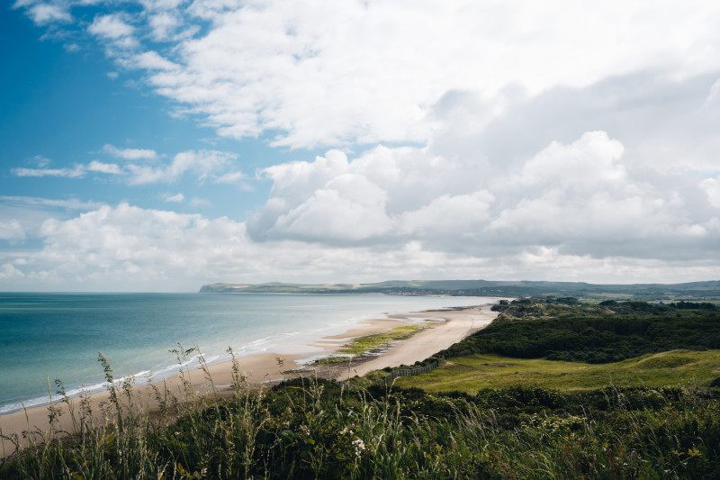 Belle photo d'un champ herbeux près de la plage sous un ciel nuageux en France