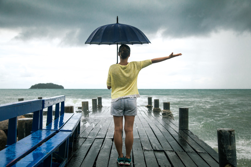 jeune fille sur la jetée avec parapluie se dresse le dos à la mer