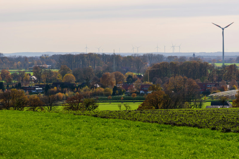 Wind turbines stand tall over a rural landscape