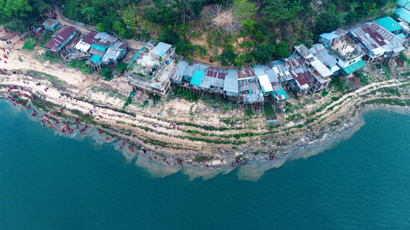 Prise de vue aérienne d'un village rustique le long du rivage à Rangamati, au Bangladesh, montrant le contraste entre la nature et l'habitat.