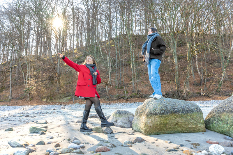 Des amis heureux marchant près d'un rocher sur la plage deux femmes sur les rochers à l'extérieur