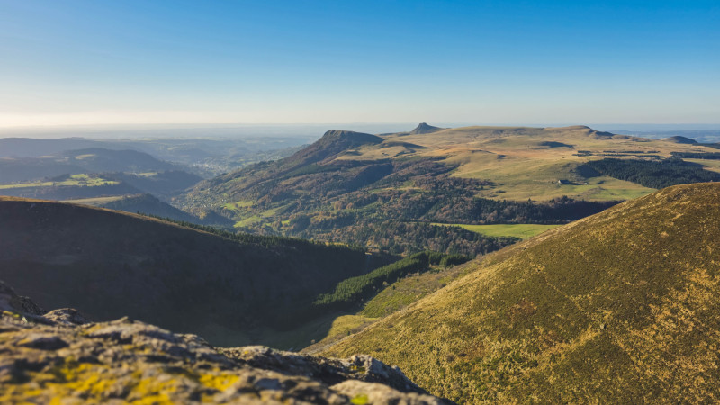 Panorama à couper le souffle des collines et vallées d'Auvergne-Rhône-Alpes en plein jour.